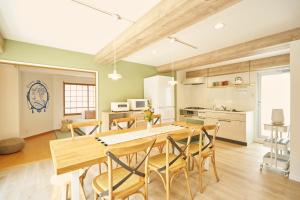 a kitchen and dining room with a wooden table and chairs at 25 min to Shibuya by Train 1 min to Sta 86 square meters in Kugayama