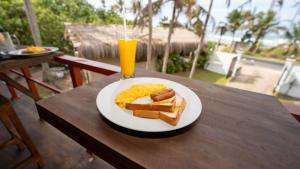 アハンガマにあるThambara Collection Boutique Hotelの朝食用の食品(1皿)とオレンジジュース