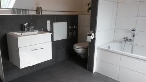 a bathroom with a toilet and a sink and a tub at Ferienwohnung Wesertraum in Hannoversch Münden