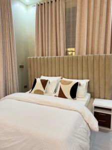 a bedroom with a large white bed with pillows at A square appartment 2 bed room in Dar es Salaam