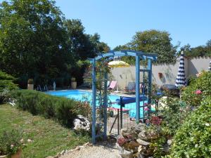 a swimming pool with a blue playground in a yard at Chat Noir Gite et Chambre D'Hotes in Génouillé