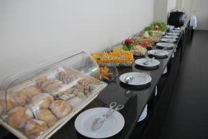 a long buffet line with plates of food on them at Hotel Monte Lírio in Espinho