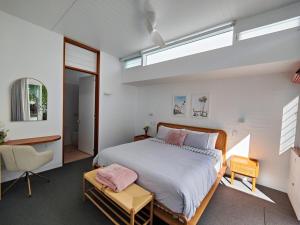 a bedroom with a large bed and a desk at Pool House, luxury 2 bedroom with ocean views, pool and sauna in Lennox Head
