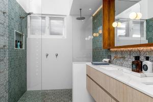 a bathroom with a shower and a sink and a mirror at Pool House, luxury 2 bedroom with ocean views, pool and sauna in Lennox Head +16 photos