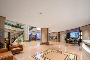 a large lobby with a staircase and a living room at Guangzhou Hutian Hotel in Guangzhou