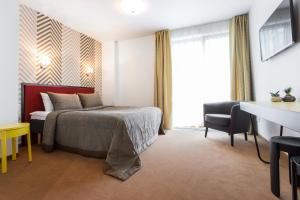 ein Hotelzimmer mit einem Bett und einem Schreibtisch in der Unterkunft Viešbutis Simpatija in Druskininkai