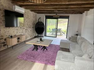 una sala de estar con un sofá y una mesa en SCI Maison Rouge 1, en Bonnac-la-Côte