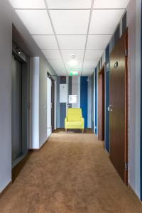a hallway with a yellow couch in an office building at Viešbutis Simpatija in Druskininkai