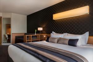a hotel room with a large bed in a room at Best Western Plus Paris Saclay in Saclay +72 photos