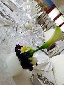 a vase filled with flowers on a table at Hotel da Rita in Condino