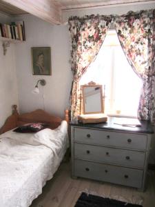 a bedroom with a bed and a dresser and a window at Rensmurs Hattstuga in Sala