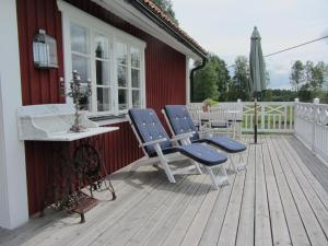 a deck with chairs and a table and an umbrella at Rensmurs Hattstuga in Sala