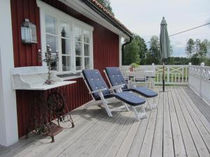 a deck with chairs and a table and an umbrella at Rensmurs Bed & Breakfast in Sala