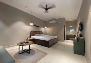 a bedroom with a bed and a table in it at The Twelve Palm Resort in Morjim