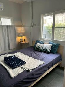 a bed in a room with two windows at Cat in the box homestay in Godown