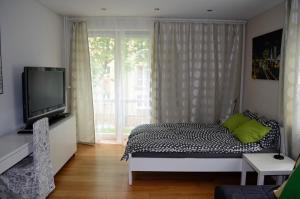- une chambre avec un lit, une télévision et une fenêtre dans l'établissement Studio Solidarności, à Varsovie