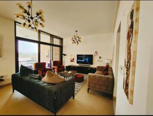 a living room with a couch and chairs and a television at Nameer bay in Bandar Jişşah