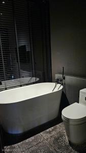 a bathroom with a white tub and a toilet at inchantreemeedao in Ban Chuk Kum +45 photos