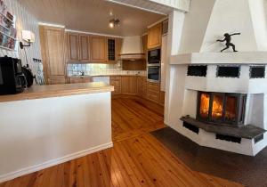 a kitchen with a fireplace in the middle of it at Feriehus ved Nisser med egen strand, brygge, peis og robåt til fri bruk in Kyrkjebygdi +19 photos