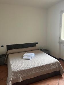 una camera da letto con un letto con due asciugamani sopra di Franciacorta Home a Rovato