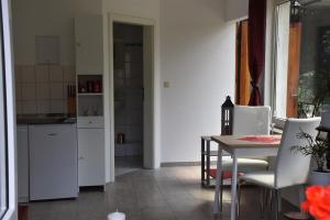 a kitchen with a table and a white refrigerator at Ferienhaus Hübner in Leipzig