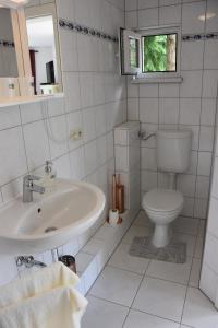 a white bathroom with a sink and a toilet at Ferienhaus Hübner in Leipzig