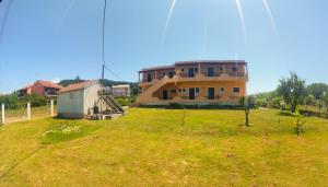 a large house in a field with a yard at Feakes Apartments in Arillas