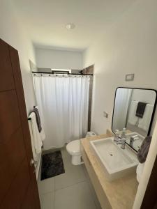 a bathroom with a sink and a toilet and a mirror at Take A Break in El Suazal