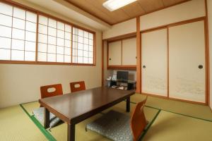 a dining room with a table and chairs at サンホテル大間 in Ōma