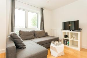 ein Wohnzimmer mit einem Sofa und einem Flachbild-TV in der Unterkunft JOIVY Lovely 1-Bed Flat near 02 Arena in London