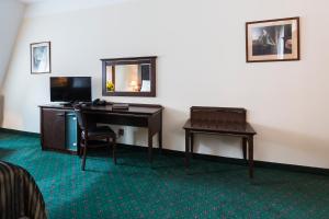 um quarto de hotel com uma secretária e um espelho em Hotel William em Praga