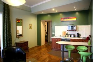 cocina con paredes verdes, mesa y sillas en Apartamenty Astur, en Cracovia
