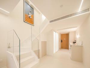 a white staircase in a house with a picture on the wall at Ouchen International Sky River Hotel (Monument to the people's Liberation Pedestrian Street Store, Chongqing) in Chongqing +146 photos