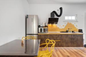a kitchen with a stainless steel refrigerator and a table at Honey Home With Parking in Laives