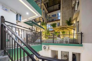an apartment staircase with a balcony with tables and chairs at Yunzhilu Boutique Hotel in Jinghong