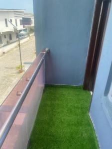 a balcony with green grass on the side of a building at Babs Apartment in Lekki +7 photos