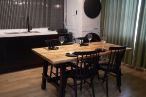 a wooden table with four chairs and wine glasses at LAY House #행궁동 #행리단길 #도보5분 #스타필드 in Suwon