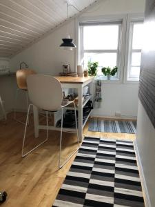 Habitación con escritorio, mesa y sillas. en Central seaview apartment with balcony, en Tromsø