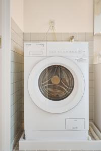 a white washing machine sitting in a bathroom at 25 min to Shibuya by Train 1 min to Sta 86 square meters in Kugayama +39 photos