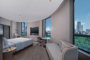 a hotel room with a bed and a couch at Holiday Inn Express Shanghai on The Bund by IHG in Shanghai