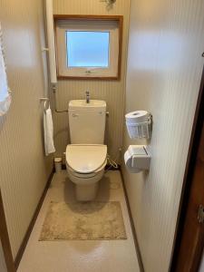 a small bathroom with a toilet and a window at Hostel&Bar クツカンタ in Rishiri +21 photos