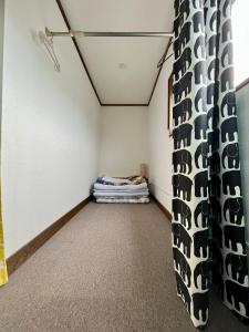 a room with a curtain and a bed in it at Hostel&Bar クツカンタ in Rishiri