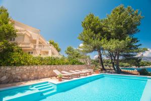 a villa with a swimming pool and trees at Aqua residence in Basina