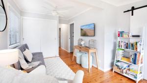 a living room with a couch and a table at Sandy Paws in Culburra Beach