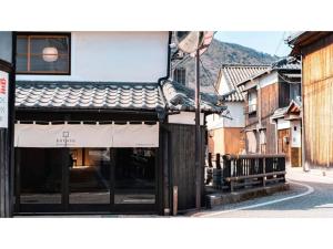 a building with a bench next to a street at Kominka Hotel kurasu - Vacation STAY 93210v in Tatsuno
