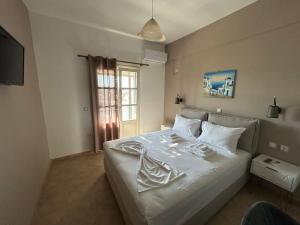 a white bed in a room with a window at MARGARITA'S-STUDIOS in Koufonisia