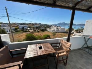 a wooden table and chairs on a balcony with a view at MARGARITA'S-STUDIOS in Koufonisia