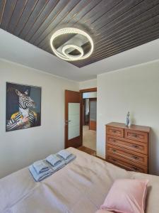 a bedroom with a bed and a dresser and a ceiling at Silver Chopin Apartment 15 Lubartów in Lubartów