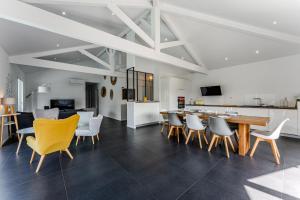 una sala da pranzo e una cucina con tavolo e sedie di La villa Sirelis piscine et spa a Gujan-Mestras