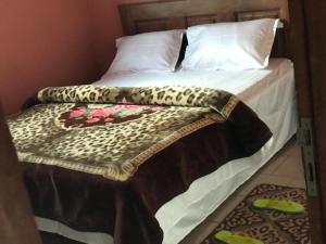 a bed with a leopard print blanket on it at Prisca home news 